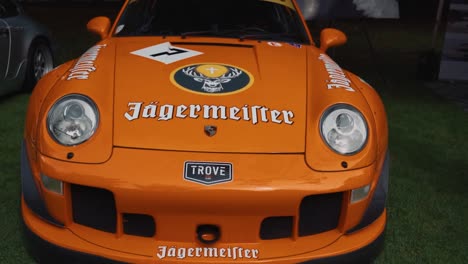 Toma-De-Barrido-De-Un-Porsche-Orane-Rough-World-Term-En-Una-Exhibición-De-Autos-De-Lujo