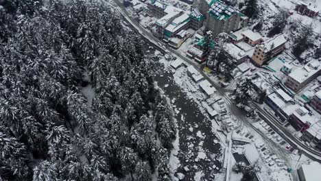 Aerial-Flyby-shot-of-Old-Manali-town-covered-with-snow-right-after-a-heavy-snowfall-during-the-winters-shot-with-a-drone-in-4k