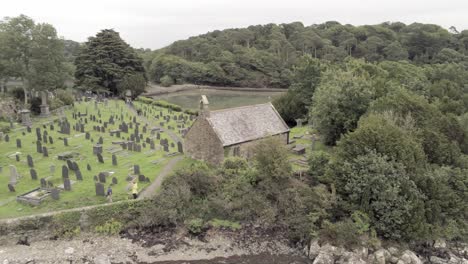 Besucher,-Die-Durch-Den-Friedhof-Auf-Tysillio-Church-Island-Auf-Der-Menaistraße-Gehen,-Anglesey,-Wales,-Luftbild