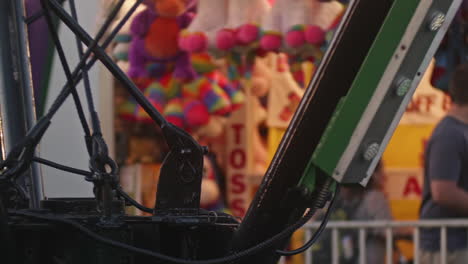 Center-of-spinning-carnival-ride-at-dusk-with-flashing-lights,-Close-Up,-Slow-Motion