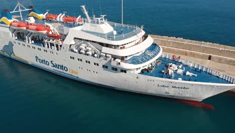 Aerial-shot-flying-backwards-Reveal-Lobo-Marinho-cruise-Ship,-Porto-Santo-Harbor