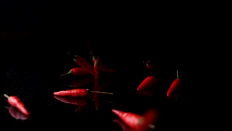 Fresh-red-chilli-spices-falling-on-a-black-background-with-reflection