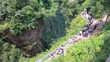 Crowds-of-tourists-taking-walking-on-the-scenic-path-on-the-viewpoint-of-the-Greatest-Natural-Bridge-also-known-as-Tian-Qiao-Sky-Bridge,-Avatar-mountains-nature-park