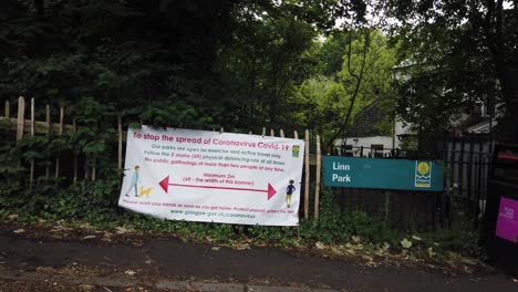 Ein-Coronavirus-Gesundheitsplakat-Vor-Einem-öffentlichen-Park-In-Glasgow