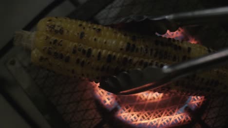 placing-Corn-on-the-cob-cooking-on-a-gas-stove-over-a-grill-from-above-slow-motion