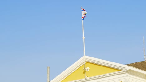 Flag-Of-The-Governor-Of-Curacao-Waving-With-Bright-Blue-Sky-In-Background---slowmo