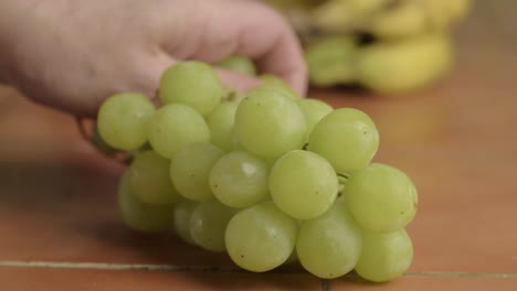 Hand-picking-from-bunch-of-white-grapes-to-eat-close-up-shot