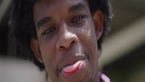 Junger-Afrikanisch-amerikanischer-Mann-Lächelt-In-Zeitlupe-In-Die-Kamera,-Nahaufnahme
