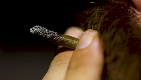 Macro-Y-Cámara-Lenta-De-Una-Articulación-De-Cannabis-En-Llamas,-Hombre-Fumando