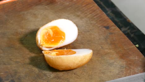 Close-up-Footage-of-Chef-Cutting-Whole-Deep-Fried-Egg-into-Half-to-Show-Juicy-Yolk-inside