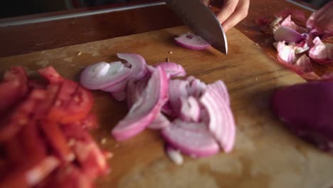 Woman-hand-Using-Knife-And-Cutting-Onion-On-Wooden-Cutting-Board