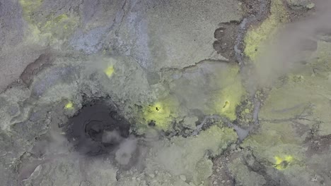A-drone-shot-of-a-mud-geyser-bubbling-with-yellow-sulfur-on-top-of-Mount-Garbuna-in-Papua-New-Guinea