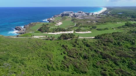 Take-back-with-drone,-overlooking-the-construction-of-a-large-Roco-Ki-Hotel,-overlooking-the-golf-courses,-in-Macao-Dominican-Republic