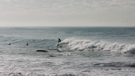 Ein-Surfer-überquerte-Eine-Welle-Und-Vermied-Dabei,-Bei-Ebbe-Einen-Felsbrocken-Aus-Dem-Pazifischen-Ozean-Zu-Ragen
