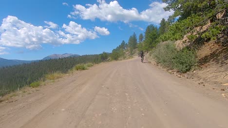 POV-passing-a-mountain-biker-while-driving-up-a-gravel-mountains-pass-in-the-Rocky-Mountains-of-Colorado---exciting-off-road-expedition