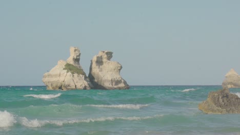 Slowmotion-wide-shot-of-the-two-sisters-with-clear-blue-sky-and-turquoise-water