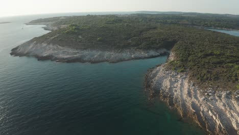 Aerial-shot-of-a-small-lagoon-at-Cape-Kamenjak,-Drone-dollies-in-to-reveal-more-details