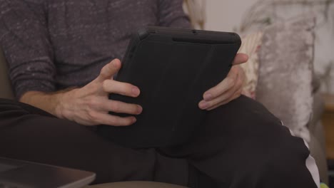 Hombre-Relajándose-Y-Sentado-En-El-Sofá-Usando-Una-Tableta-En-Modo-Horizontal