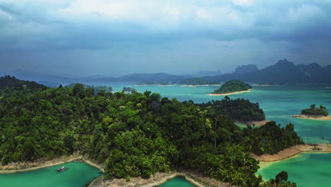 shadows-moving-over-green-tropical-forest-floating-houses,-khao-sok,-aerial