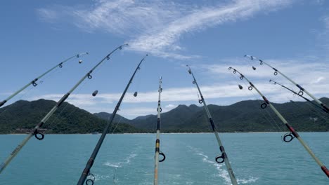 Fishing Rods Hanging From Back Of Boat Facing Mountains In