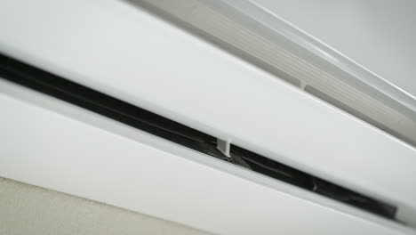 White-Air-Conditioner-is-Turning-on-with-Swing-Function-and-Blowing-Cold-Air-in-Bright-Room