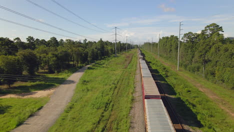 Aerial-view-of-cargo-train-standing-in-forest-near-city