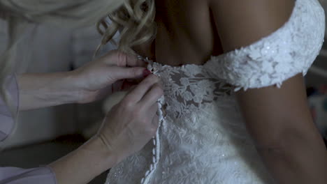 Bridesmaid-adjusting-bride's-wedding-dress