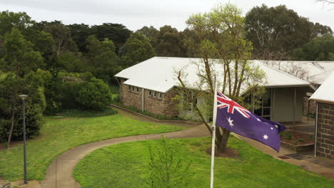 AERIAL-Flying-Past-Australian-Flag-Into-Primary-School-Grounds