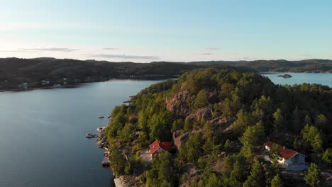 Beautiful-Norwegian-fishing-village-on-island-hillside,-summer-4K-aerial-view