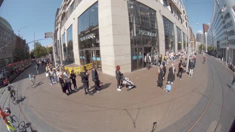 Fish-Eye-View-Of-People-In-Queue-Line-Outside-A-Primark-Retail-Store-In-The-Hague,-Netherlands---Coronavirus-Pandemic---New-Normal