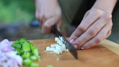 Chef-slicing-garlic-on-the-cutting-board-with-a-knife,-Cooking-Stock-Footage,-Kitchen-Stock-Footage,-Clay-Product-Stock-Footage