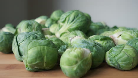 Slow-Motion-Push-In-Shot-Towards-Heap-of-Fresh-Raw-Brussels-Sprouts-on-Wooden-Tabletop