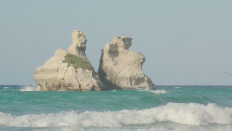 Slowmotion-close-up-shot-of-the-two-sisters-with-clear-blue-sky-and-wavy-turquoise-water