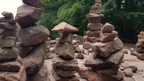 Close-up-zoom-out-of-small-rock-balancing-on-top-of-stacked-rocks-on-table