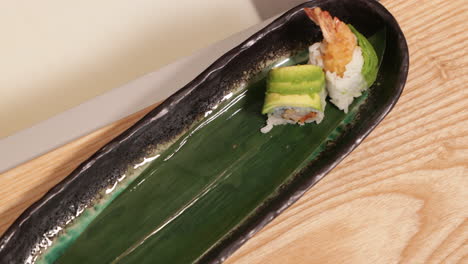 Hände-Eines-Sushi-Kochs,-Der-Sushi-Rollen-Sorgfältig-Auf-Den-Teller-Legt-Und-Aufreiht