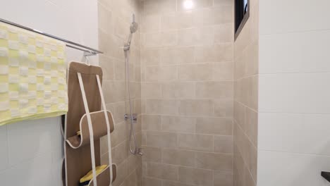 Einfaches-Und-Sauberes-Badezimmer-Mit-Beigefarbenen-Fliesen-Und-Duschkopf