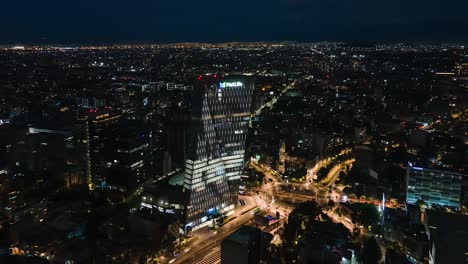 Aerial-drone-lapse-view-around-the-Torre-Manacar-shopping-center-in-the-Insurgentes-Mixcoac-neighborhood,-during-night-time,-in-Mexico-city,-America---Orbit,-hyperlapse-shot