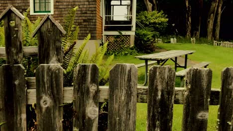 Walking-by-a-weather-unique-bird-house-decorated-fence-at-the-coast-guard-housing-Port-Orford-Heads,-Oregon-in-the-Pacific-Northwest