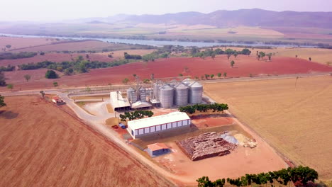 Grain-storage-silos-and-stunning-scenery,-high-angle-orbiting-aerial-view
