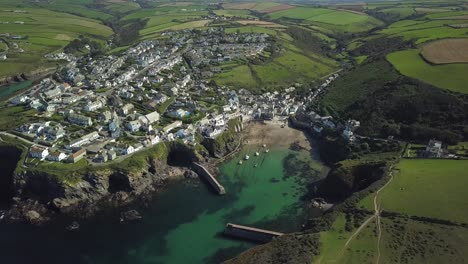 The-quiet-Port-Isaac-Village-in-England-by-the-sea--aerial-tilt-down