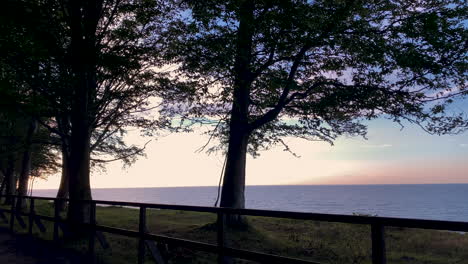 Wunderschöne-Blaue-Und-Rosa-Farben-Des-Sonnenuntergangs-über-Dem-Ruhigen-Ozean-In-Der-Nähe-Des-Waldparks-Im-Dorf-Jastrzebia-Gora,-Polen