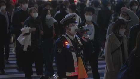 Policeman-Speaking-To-The-Crowd-Using-A-Megaphone-On-Halloween-Night-At-Shibuya-Crossing-In-Tokyo,-Japan---Slow-Motion