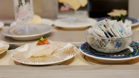 Plates-of-Sushi-on-a-Kaitenzushi-conveyor-belt-for-picking--Kyoto-Japan--closeup
