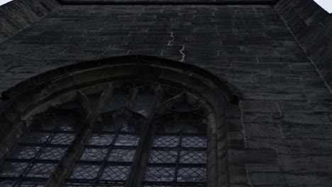 Looking-up-at-stained-windows-on-old-English-church-medium-shot