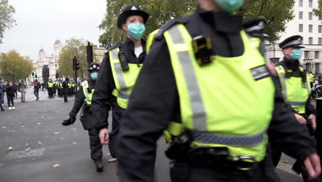Una-Unidad-De-Policía-Antidisturbios-Con-Máscaras-Protectoras-Marcha-A-Lo-Largo-De-Whitehall-Durante-Una-Protesta-De-Conspiración-De-Coronavirus-Y-Qanon