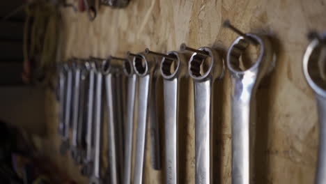 Wrenches-hanging-on-nails-above-work-bench
