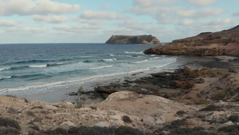 Wellen,-Die-Gegen-Die-Kalksteinstrände-Von-Porto-Santo-Mit-Einer-Anderen-Insel-In-Der-Ferne-Schlagen
