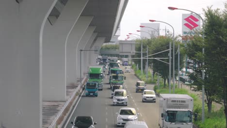 Camiones-Y-Autos-Moviéndose-Lentamente-En-La-Carretera-Con-Tráfico-Ligero-En-Saitama,-Japón---Toma-De-ángulo-Alto