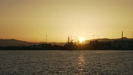View-of-Kalamata-port,-during-golden-hour,-with-beautiful-sunset,-slow-motion,-wide-