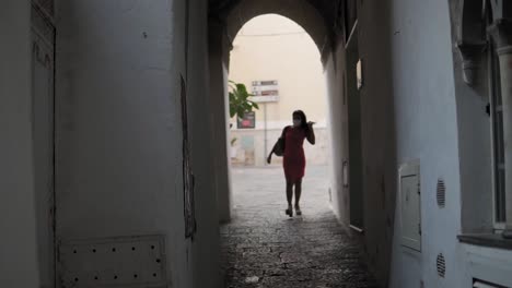 Einsame-Frau-Mit-Gesichtsmaske,-Die-Auf-Straßen-Und-Durchgängen-In-Der-Amalfi-stadt-Italien-Geht
